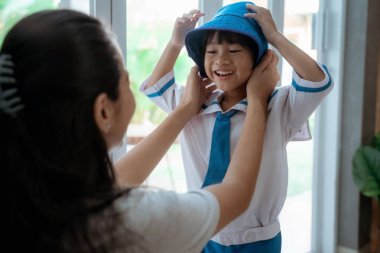 küçük çocuk annesi ile sabah okula hazırlanıyor