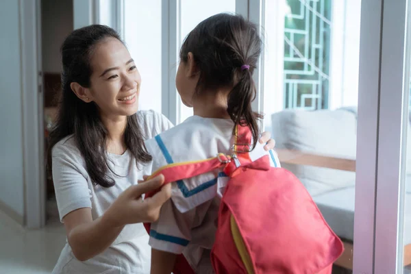 Småbarnsbarn som forbereder seg på skolen om morgenen med mamma – stockfoto