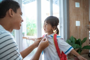 okul üniforması giyen anaokulu öğrencisi babası tarafından yardım