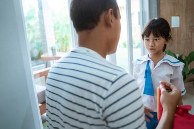okul üniforması giyen anaokulu öğrencisi babası tarafından yardım