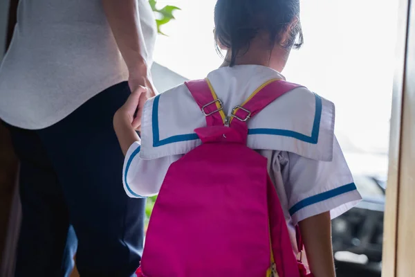 Madre cogida de la mano de la pequeña hija con mochila — Foto de Stock