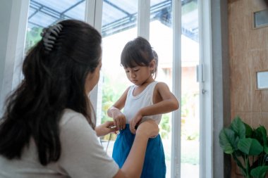 küçük çocuk annesi ile sabah okula hazırlanıyor