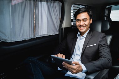 yolcu koltuğunda oturan tablet ile işadamı