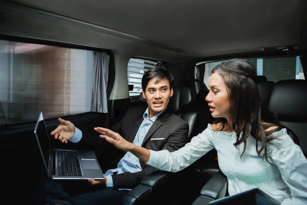Two business people meeting while sitting on passenger seat of car — Stock Photo, Image
