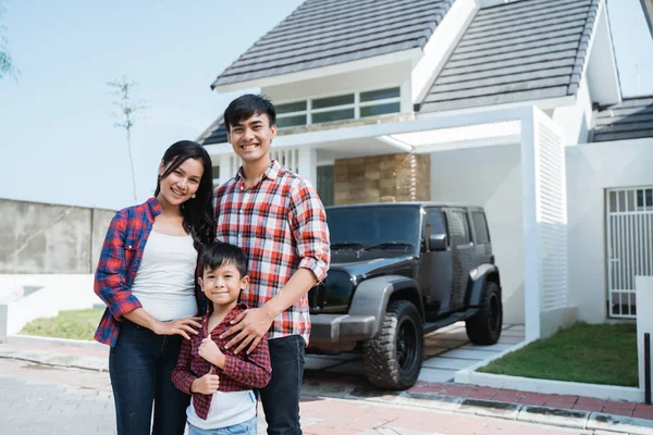 Asian family with kid in front of their house and car — Stock Photo, Image