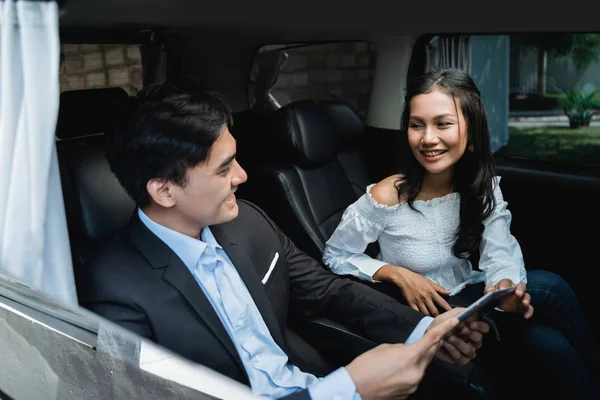 two business people meeting while sitting on passenger seat of car