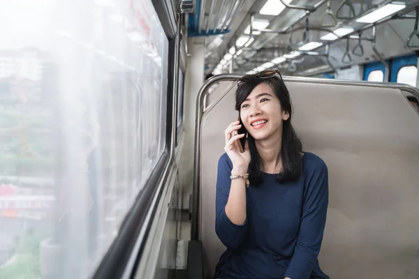 Nő élvezi a vonat utazás vagy villamossal vele mobiltelefonnal — Stock Fotó