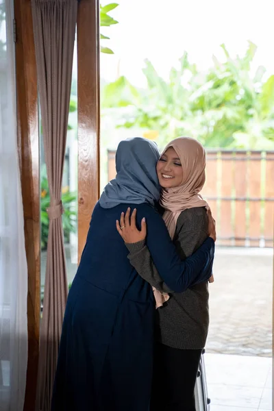 Дочь и мать обнялись, когда ее дочь вернулась домой — стоковое фото