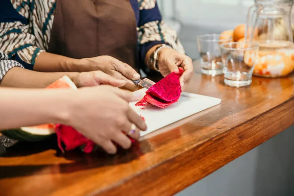 Retrato de dos mujeres rebanando una fruta de dragón — Foto de Stock