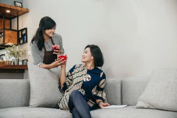 Två asiatiska kvinna chattar när du sitter i vardagsrummet — Stockfoto