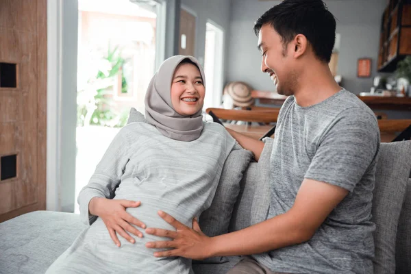 Мусульманская беременная женщина с мужем, сидящим — стоковое фото