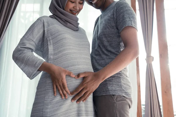 Parejas mano hacer forma de corazón en el vientre embarazada —  Fotos de Stock