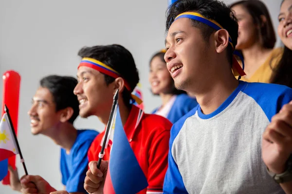 Excited asian young supporter holding philippines flag — Stock Photo, Image