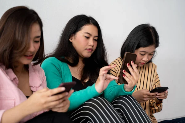 Grupo de amigos están ocupados sosteniendo sus propios teléfonos celulares —  Fotos de Stock