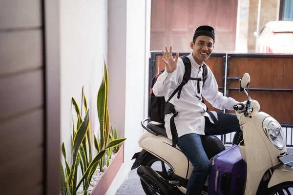 Müslüman adam idul fitri balik kampung mudik bavul taşıyan için motosiklet binmek — Stok fotoğraf