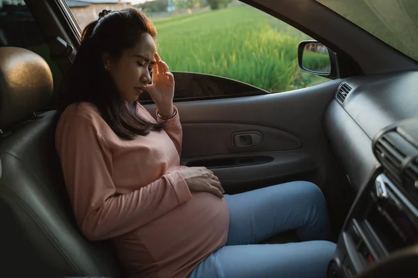 Mujer embarazada en su viaje en el coche sintiéndose mal — Foto de Stock