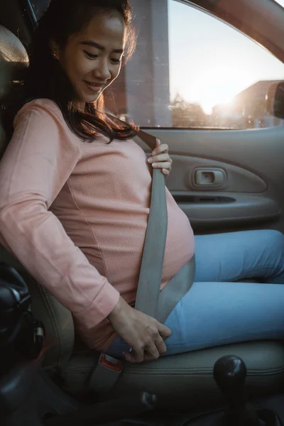 Schwangere schnallt sich im Auto an — Stockfoto