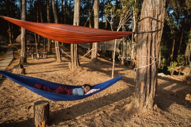 açık hamak üzerinde rahatlatıcı asyalı çocuk