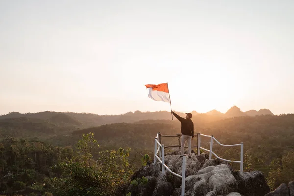 Man with indonesian flag of indonesia on top of the mountain — Stock Photo, Image