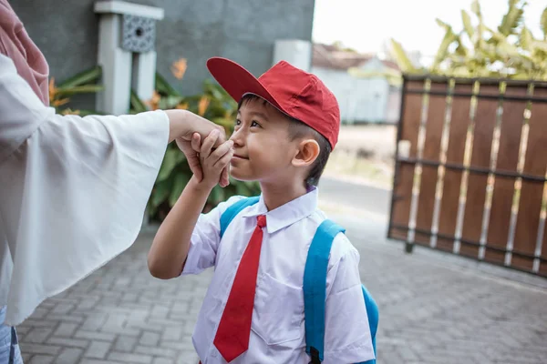Indonesia студент поцелуй матери руку перед школой — стоковое фото