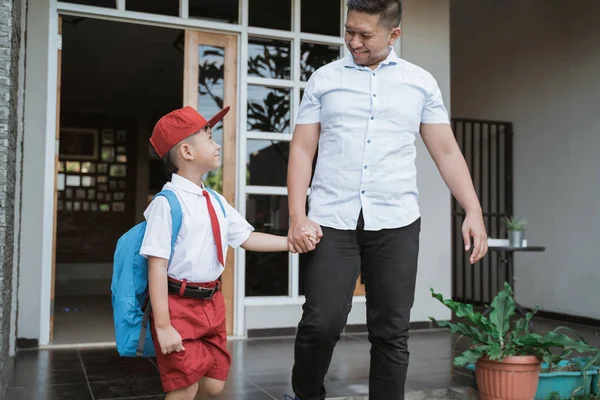 アジアの少年は父親の手を握り、学校に行く — ストック写真