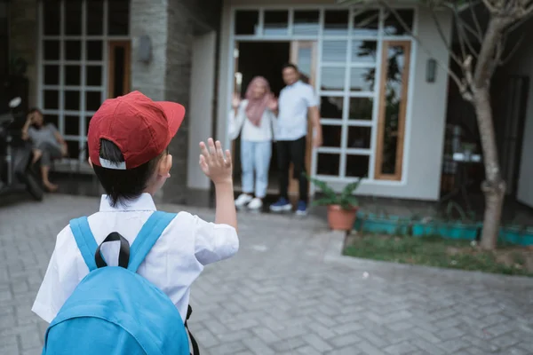 Criança acenando adeus aos pais antes da escola — Fotografia de Stock