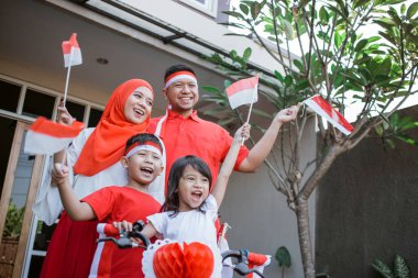 Endonezya bağımsızlık günü için bayrak ve yay ile aile dekorasyon bisiklet