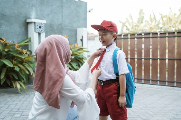 Mamma hjälpa sin son förbereder sig för skolan — Stockfoto