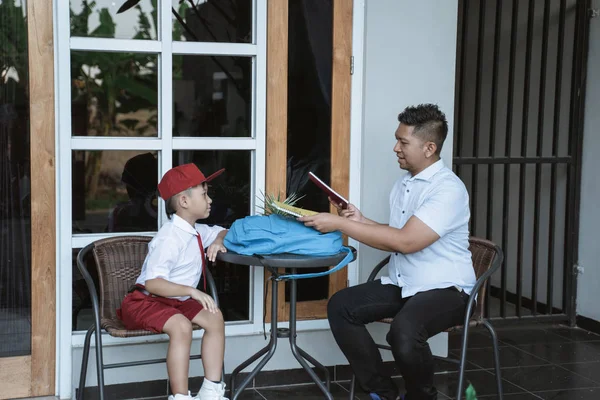 Padre ayudar a su hijo a prepararse para la escuela por la mañana —  Fotos de Stock