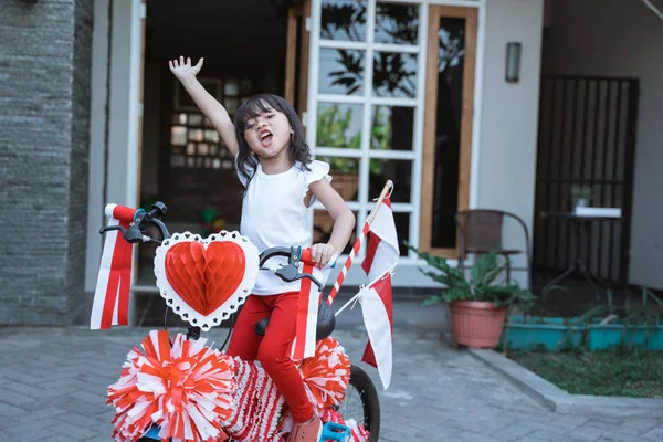 Indonesisch meisje met haar versierde fiets vol met Indonesië vlag — Stockfoto