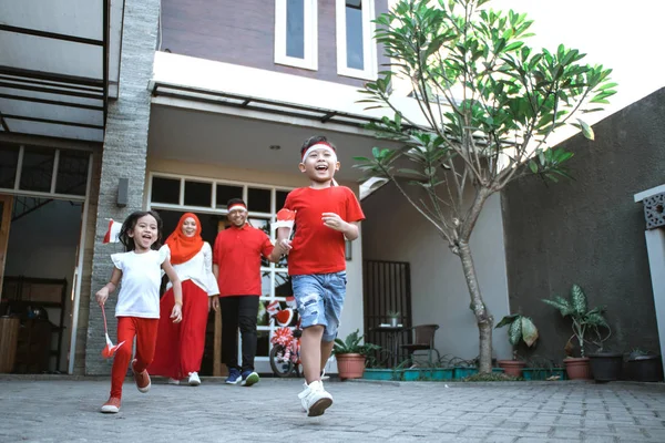 Keluarga merayakan hari kemerdekaan indonesia bersama membawa bendera — Stok Foto