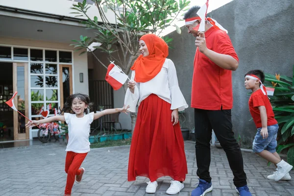 Keluarga merayakan hari kemerdekaan indonesia bersama membawa bendera — Stok Foto