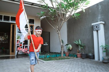 bağımsızlık gününde Endonezya bayrağı sallayan gururlu çocuk