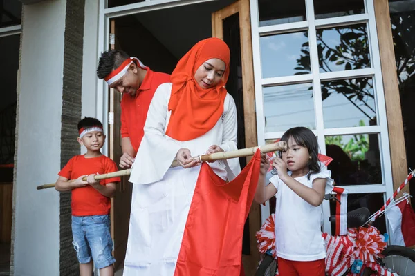 Keluarga yang mendekorasi rumah mereka untuk hari kemerdekaan indonesia — Stok Foto