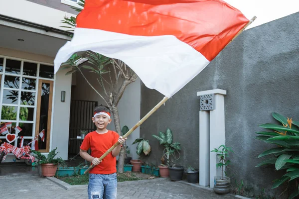 Anak bangga melambaikan bendera indonesia pada hari kemerdekaan — Stok Foto