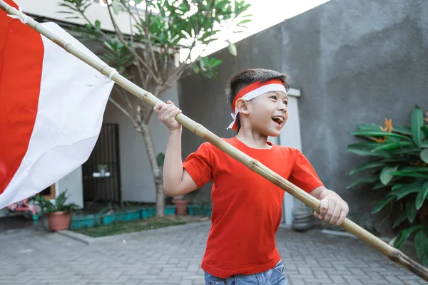 Anak angkat bendera indonesia dan berjalan di sekitar — Stok Foto