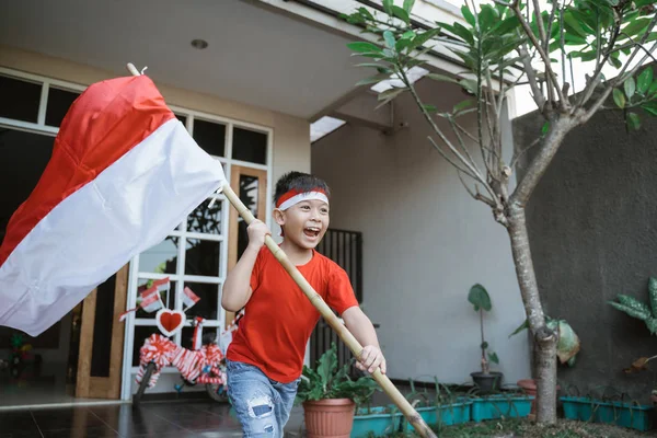 Anak bangga melambaikan bendera indonesia pada hari kemerdekaan — Stok Foto