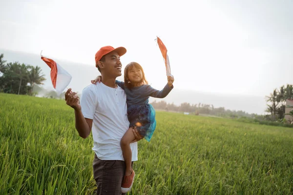Indonesisch kind met vader spelen met nationale vlag — Stockfoto