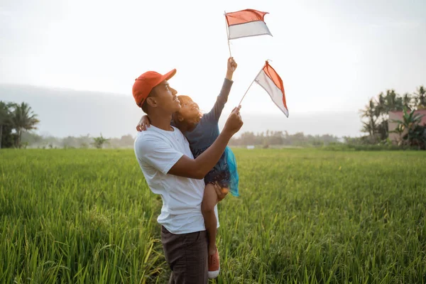 Anak indonesia dengan ayah bermain dengan bendera nasional — Stok Foto