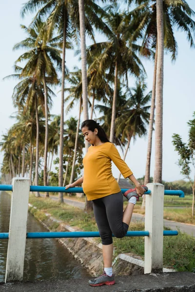 Schwangere streckt ihr Bein beim Sport im Freien — Stockfoto