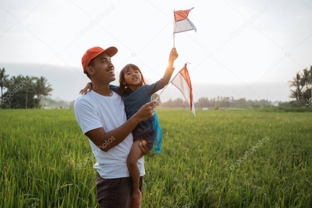 indonesian kid with father play with national flag