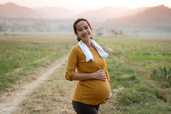 Gelukkig lachende Aziatische zwangere vrouw oefening — Stockfoto