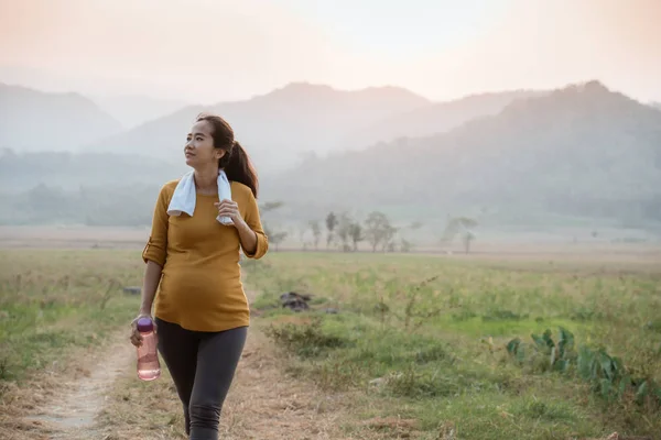 Mujer embarazada corriendo al aire libre en la naturaleza —  Fotos de Stock