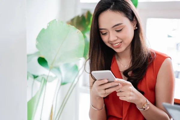 Asiatico giovane donna utilizzando smartphone in caffè — Foto Stock