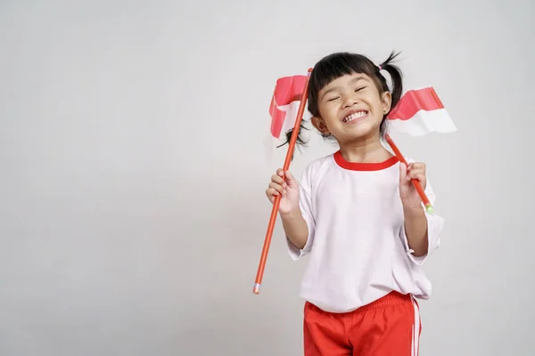 Індонезійська дитина посміхаючись до камери з прапором — стокове фото
