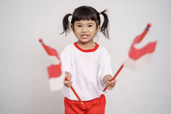 Aziatische peuter met Indonesische vlag glimlachend naar camera — Stockfoto