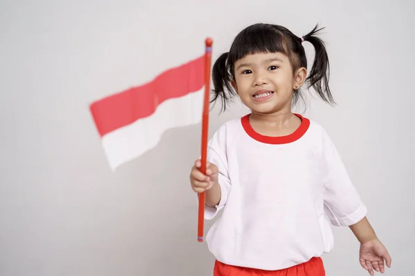 Aziatische peuter met Indonesische vlag glimlachend naar camera — Stockfoto