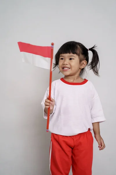 Indonesiska Kid leende till kamera med flagga — Stockfoto