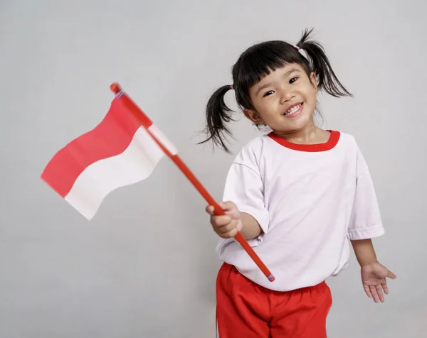 Aziatische peuter met Indonesische vlag glimlachend naar camera — Stockfoto