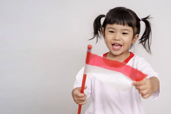 Indonesische Kid glimlachend naar camera met vlag — Stockfoto